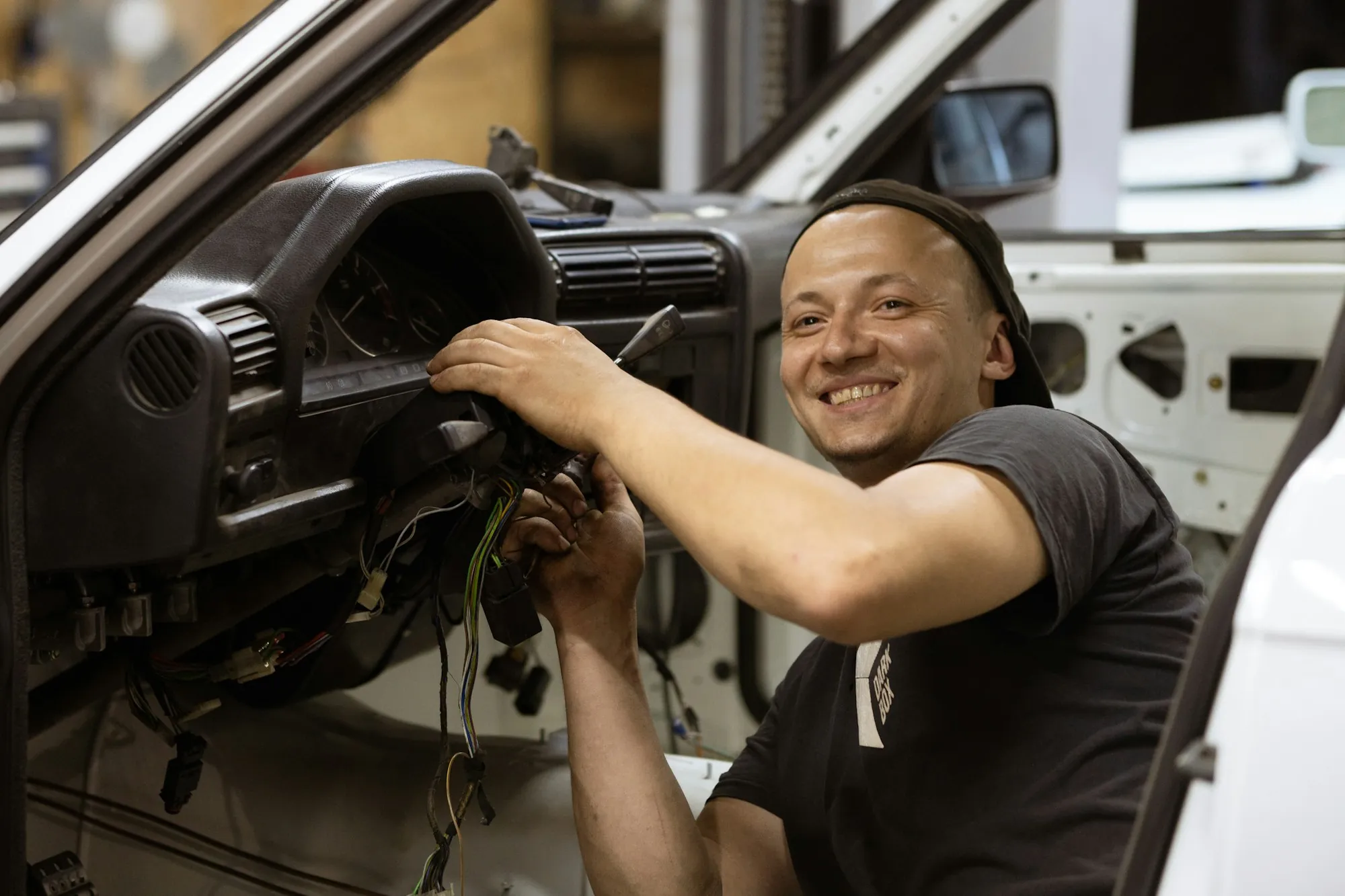 Smiling mechanic working inside a vehicle's cabin