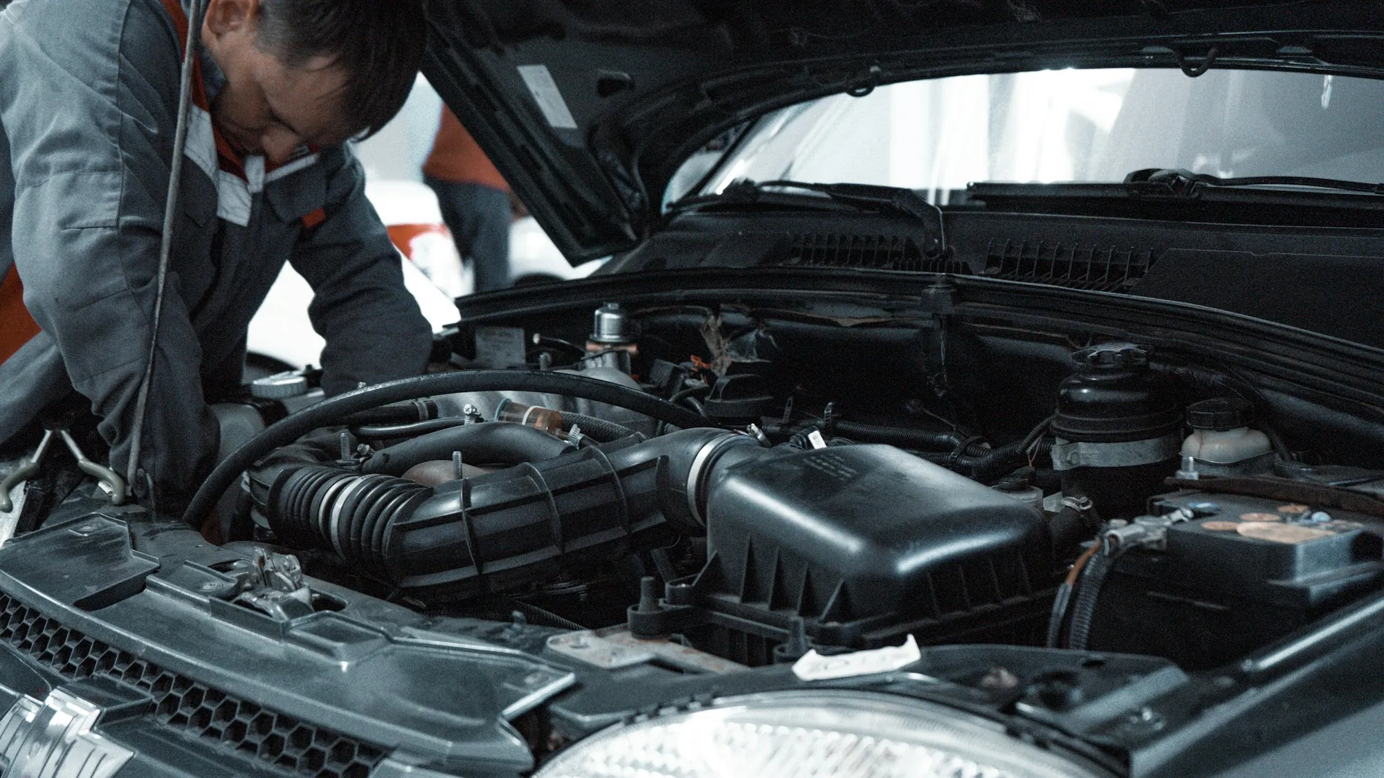 Open engine bay of a dark vehicle in a workshop
